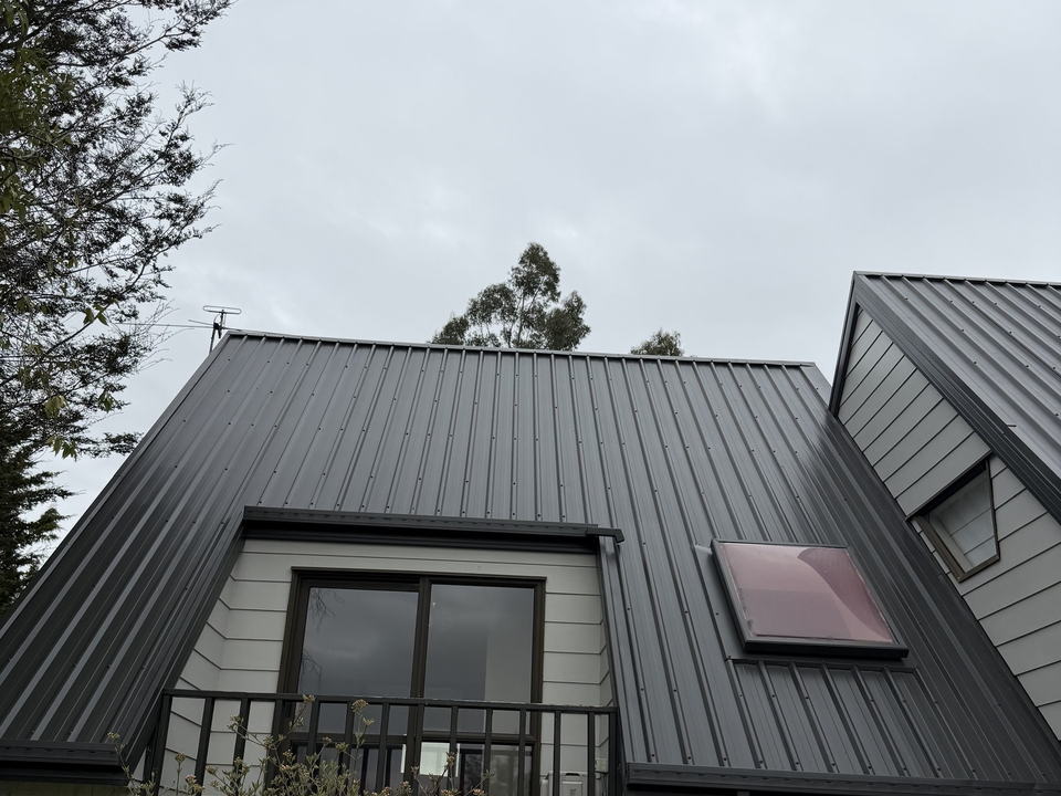 After: the same Kaiapoi roof three days later, spray coated in an even charcoal