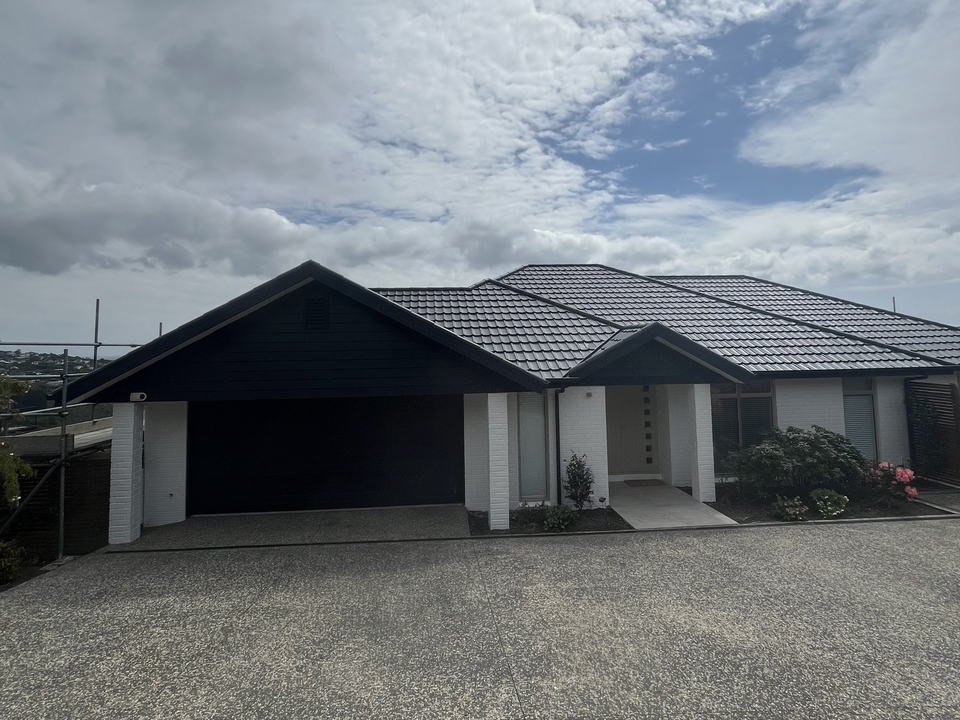 Finished dark grey concrete tile roof on a Christchurch home, clean lines along the hips