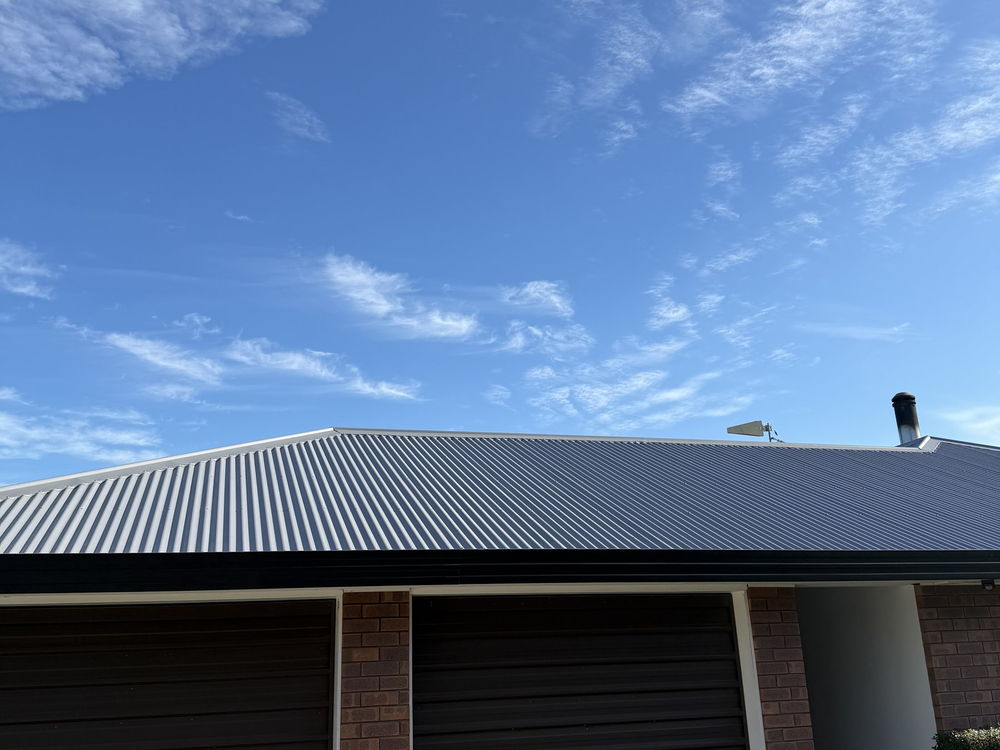 Light grey painted corrugated iron roof over a brick double garage near Lincoln