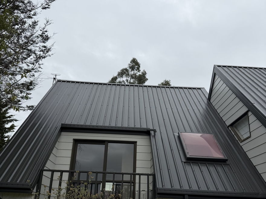 Long-run metal roof spray painted charcoal on a two storey house in Kaiapoi